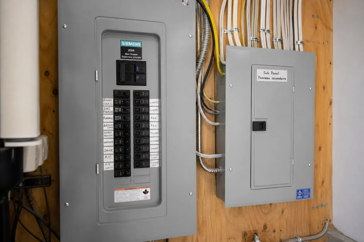 Modern 200-amp panel with a sub-panel beside it in the mechanical room of a large Castlemore, Brampton home