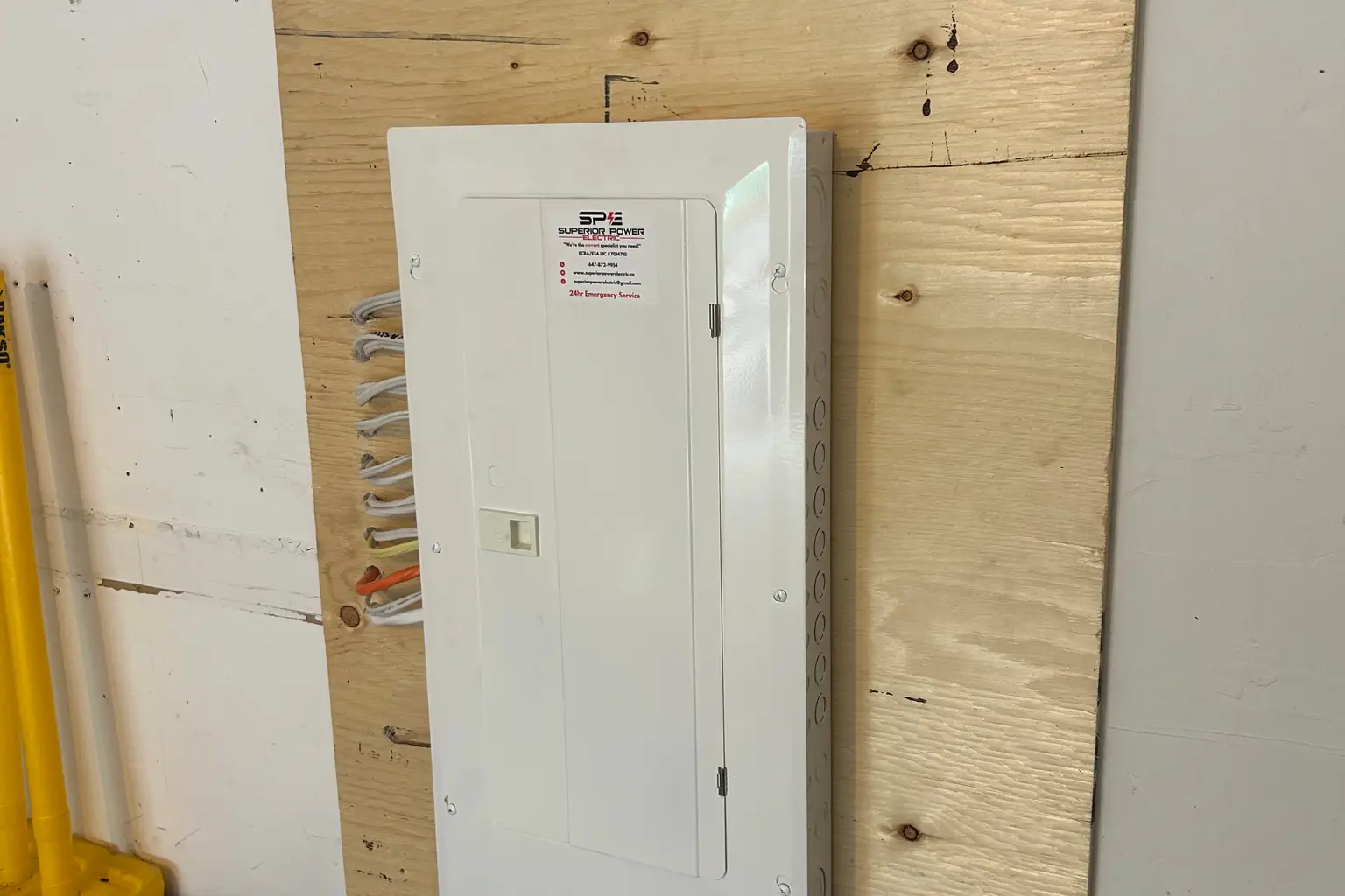 New panel installed on plywood backing during a basement wiring project