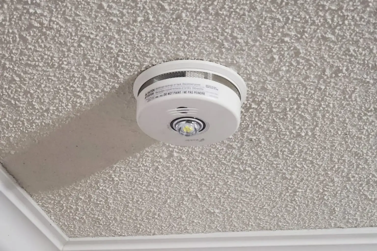 Hardwired combination smoke and CO alarm installed on a customer's ceiling