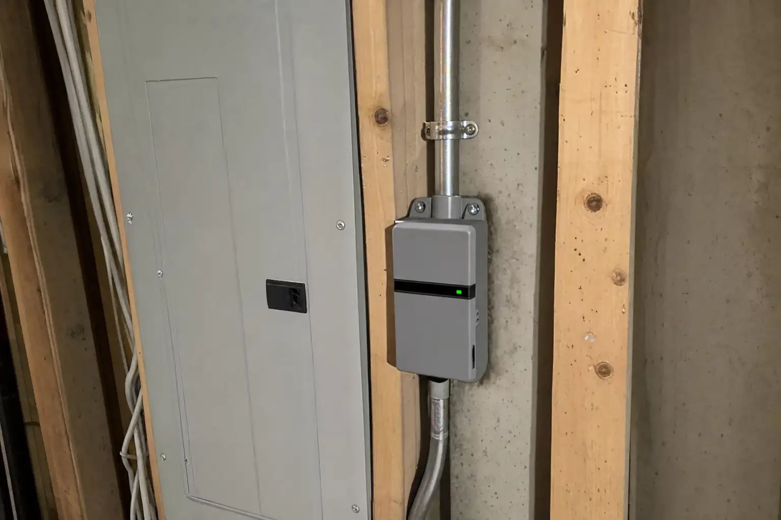 Whole-home surge protector mounted beside a breaker panel